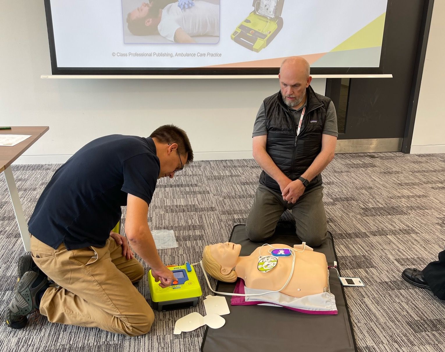 Deux membres de l’équipe britannique de Tanium pratiquant la RCP sur un mannequin CPR
