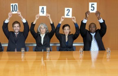 Quatre juges détenant des cartes de notation à une table