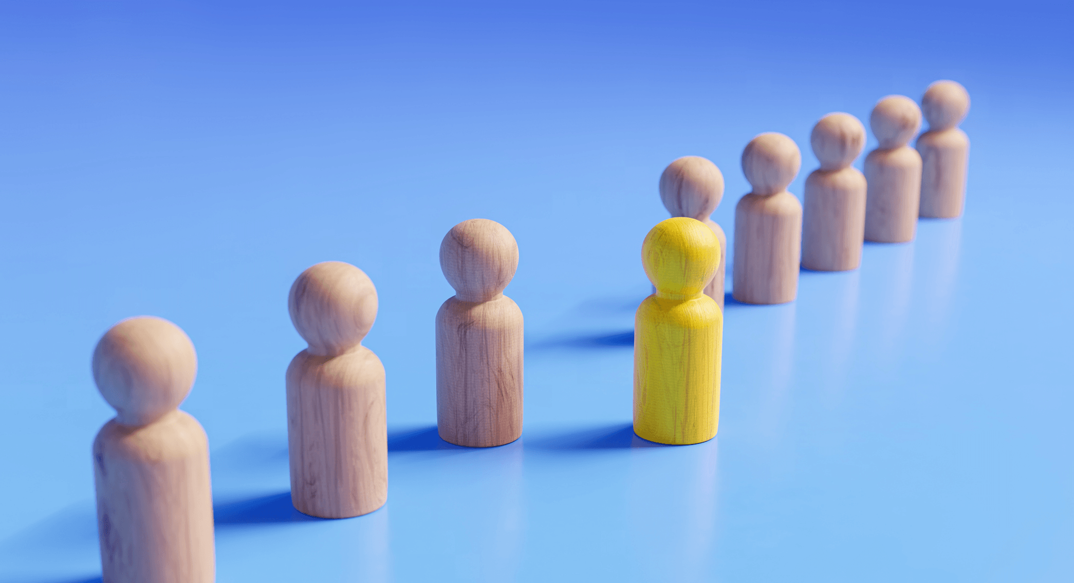 Des figures en bois se tiennent en diagonale sur un fond bleu, avec une figure jaune en avant.