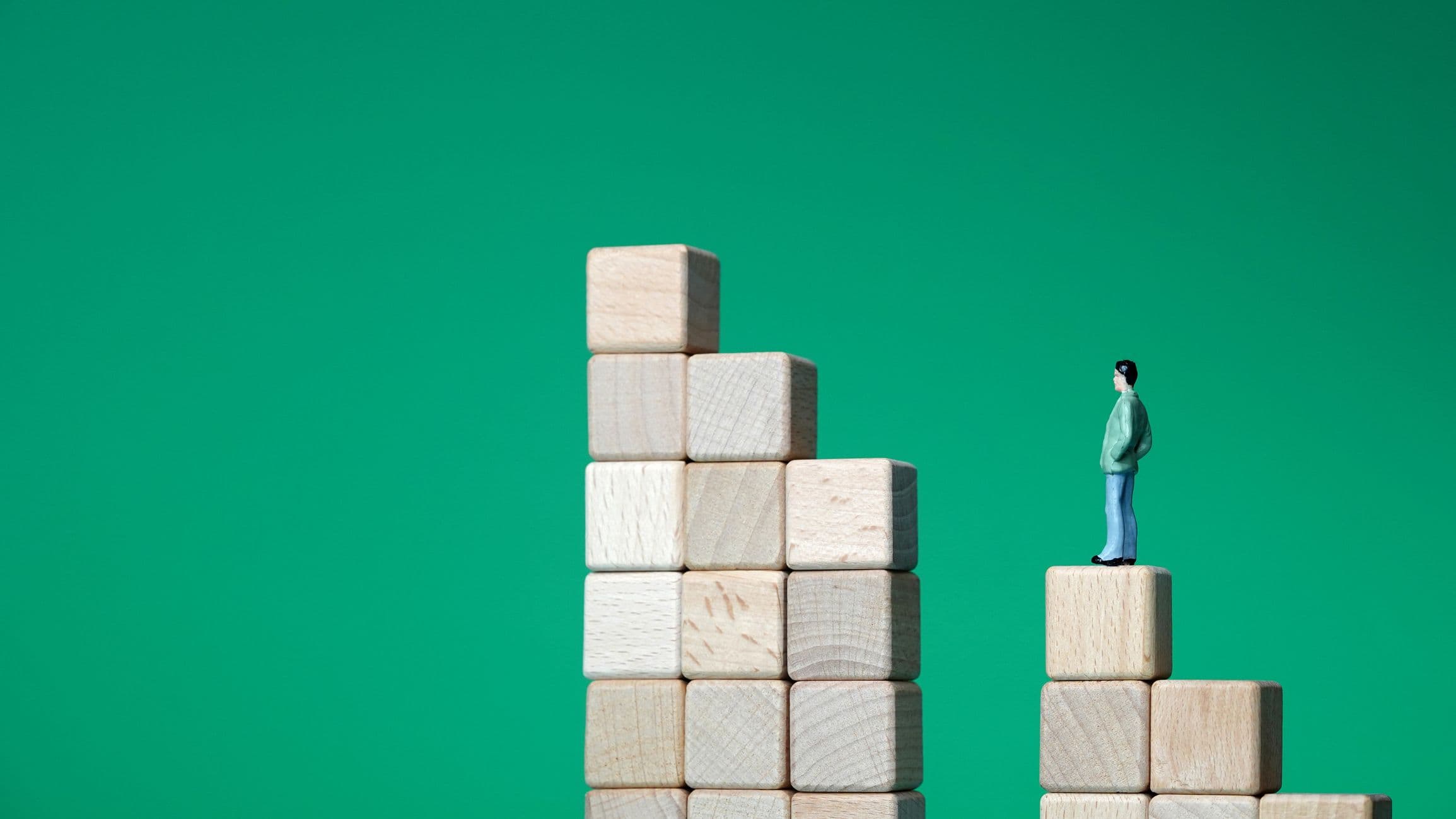 Photo d'une petite figurine représentant un homme debout sur un escalier de blocs séparé par un large fossé