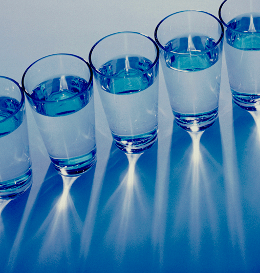 Une photo de plusieurs verres d’eau placés en diagonale et vus d’en haut.