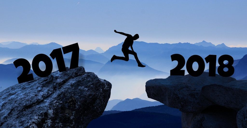 Silhouette d'une personne sautant entre les rochers numérotés 2017 et 2018