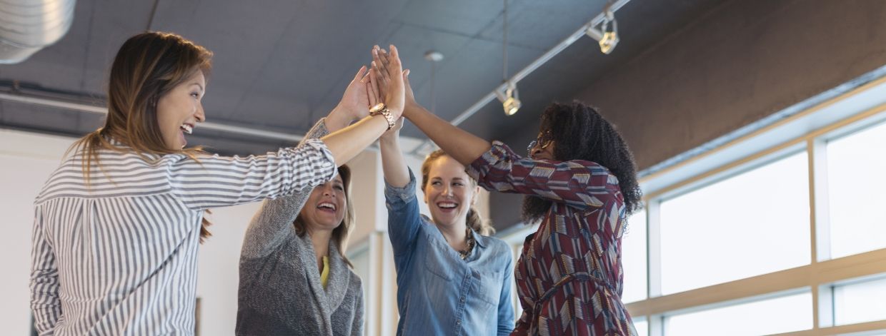 Une équipe de femmes au bureau se tapant dans la main