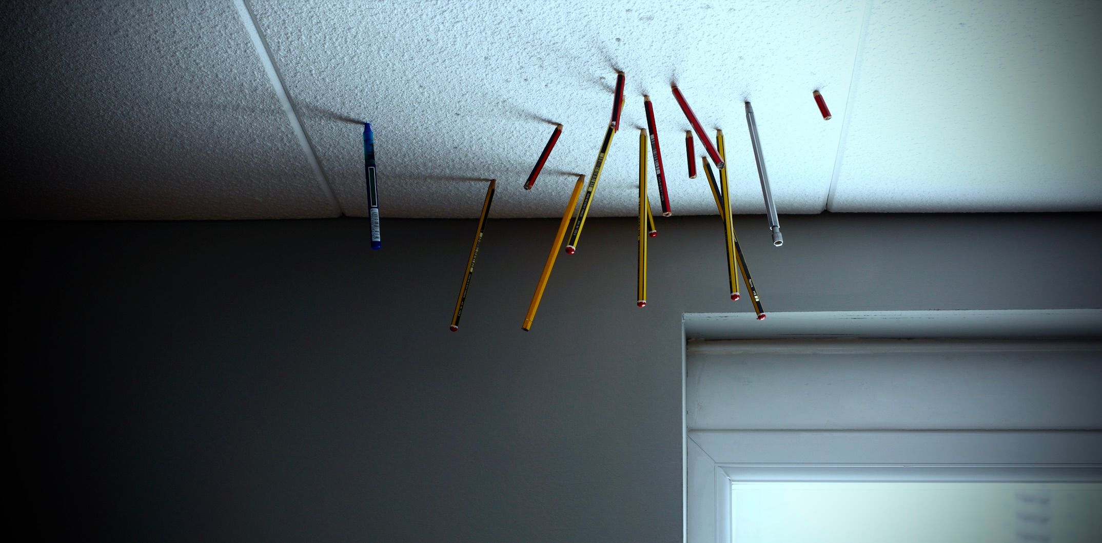 Photo de crayons plantés dans des dalles de plafond en Styrofoam.