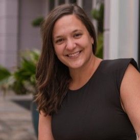 Photo d’une femme aux cheveux foncés souriant à l’extérieur