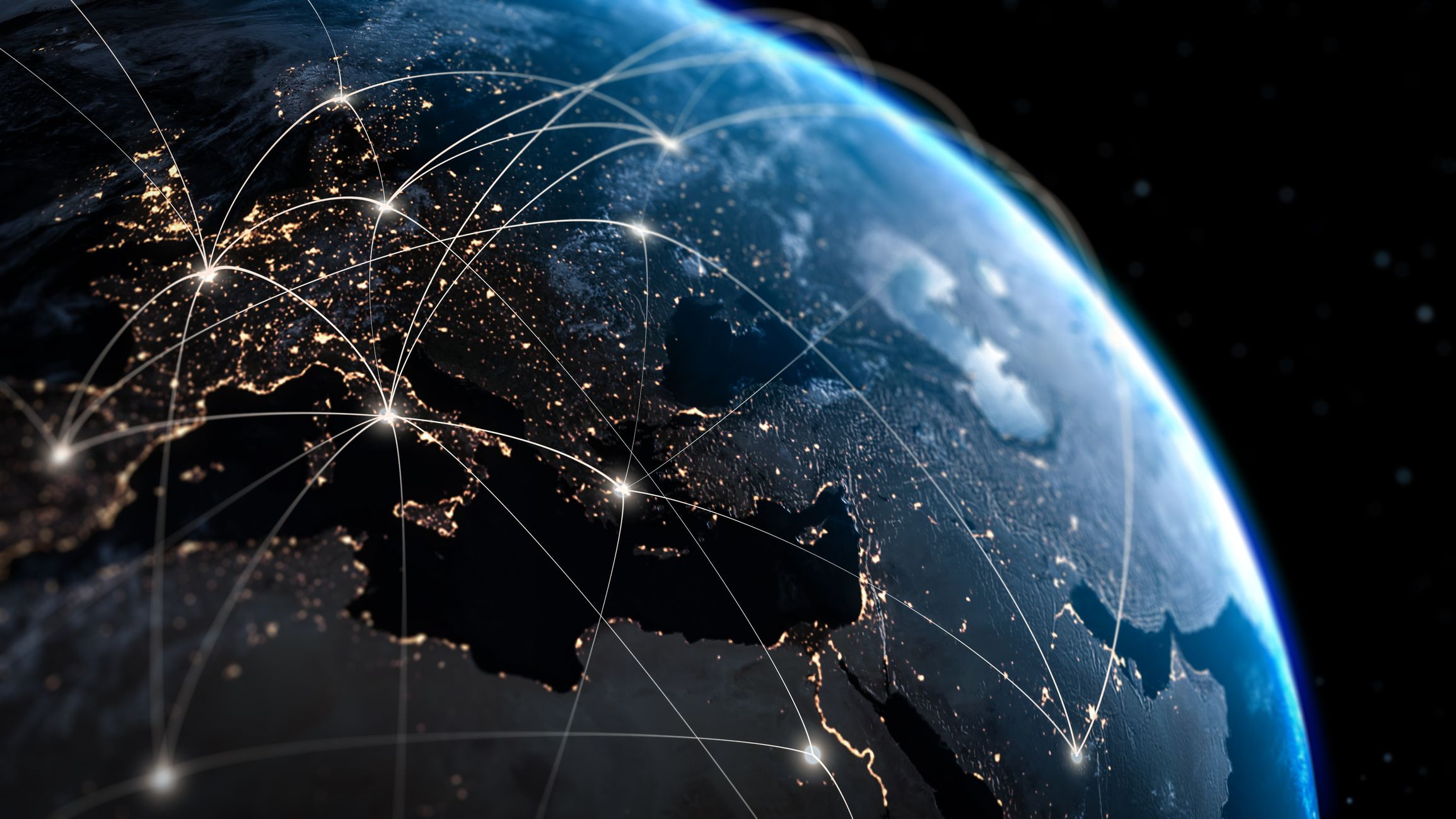 Le globe bleu de la Terre, vu depuis l'espace, avec les centres urbains européens illuminés d'une lumière dorée.