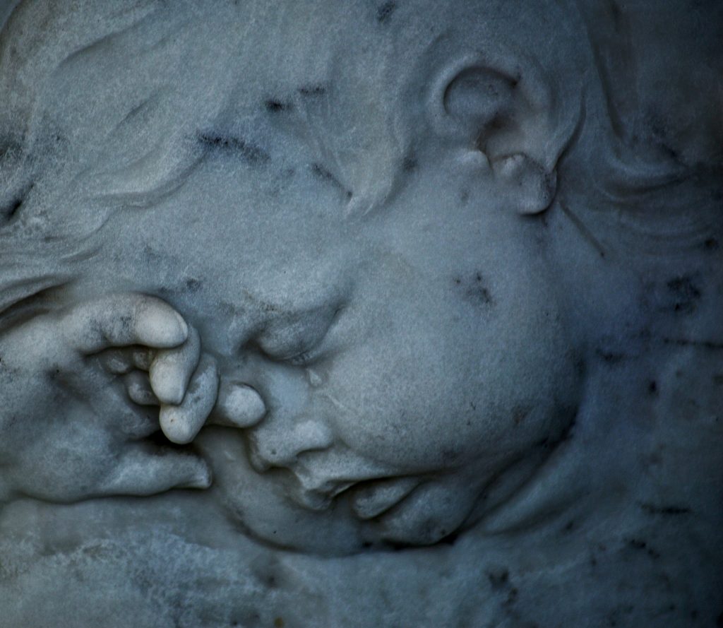 Sculpture en pierre d’une figure d’ange de chérubin endormi