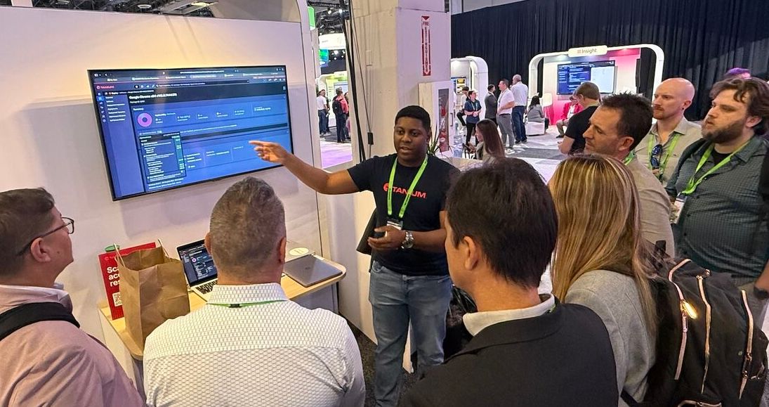 Groupe de personnes regardant une démonstration de produit sur un stand de conférence