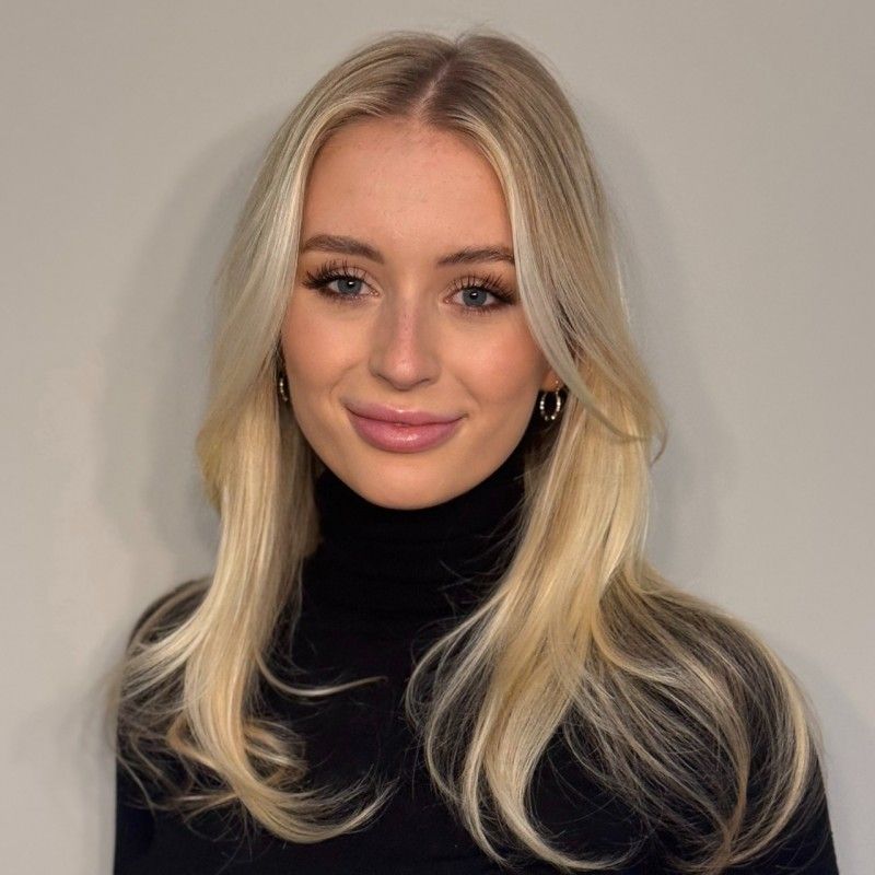 Photo d’une femme aux cheveux blonds et collier doré