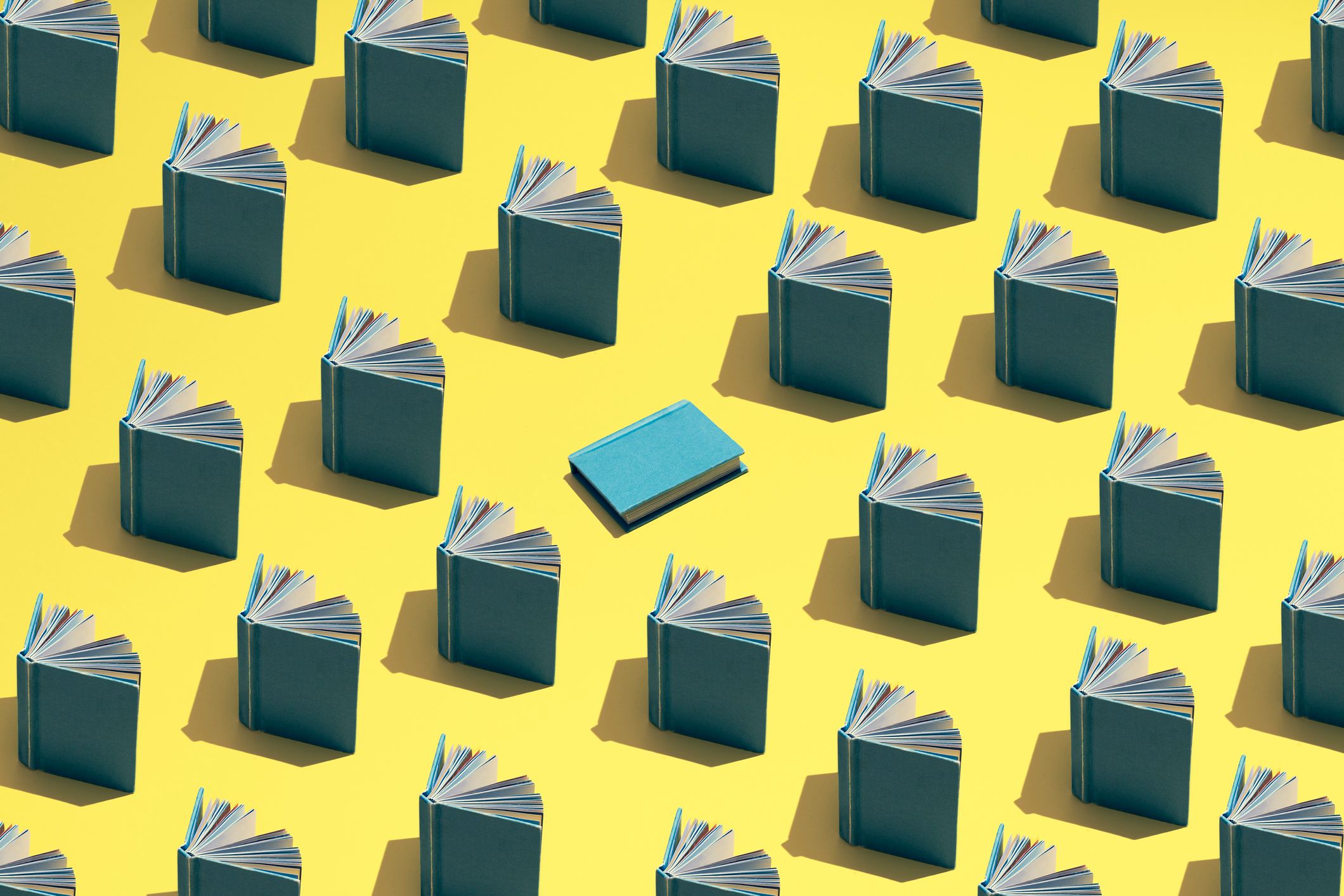 Image vedette du blog. Une illustration de livres ouverts disposés en rangées sur un fond jaune, avec un livre bleu au centre.