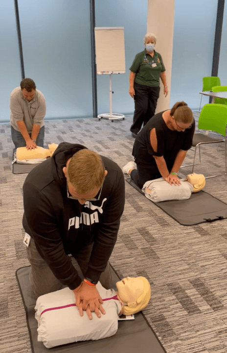 Groupe de quatre membres de l’équipe Tanium UK pratiquant la RCP sur les mannequins CPR